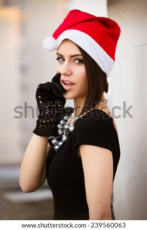 Christmas Santa hat outdoors woman portrait.Sexy seductive woman  wearing her Santa hat with urban background.Happy Christmas and New Year.Christmas woman bombshell.Beauty model girl in Santa hat