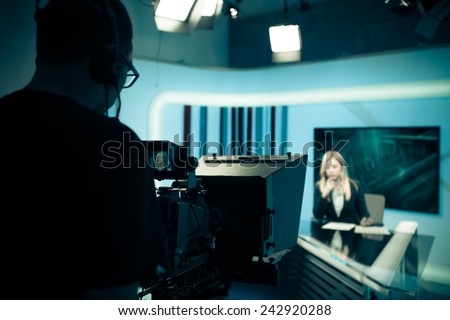 Young beautiful blonde television announcer at studio during live broadcasting.Female TV director at editor in studio.Recording at TV studio with television anchorwoman. TV NEWS studio with camera
