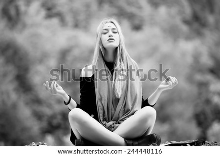 Beautiful young blonde woman meditating outdoors.Yoga woman mat outside.Calm woman meditating sitting in a park with closed eyes.Sport, meditation, park and lifestyle concept-woman meditating