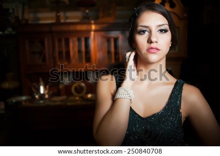 Retro fashion portrait of a beautiful woman. Vintage style. Romantic elegant beauty young woman in black evening dress posing in vintage antique interior.