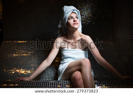 Spa woman.Beautiful girl after bath in jacuzzi spa,relaxing after massage,wrapped in towels.Skincare.Perfect smooth young exfoliated skin.Woman pleased with the results from the spa treatments