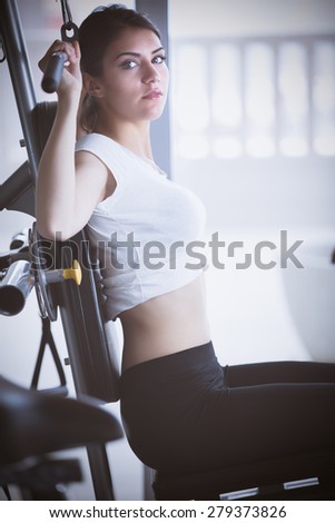 Woman weight training at gym.Exercising on pull down weight machine.Woman doing pull-ups exercising lifting dumbbells.Cardio and fat loss workout in the gym.Sport and fitness,summer body goals