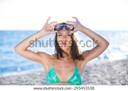 Woman on beach vacation having fun with snorkeling mask,enjoying the sun on summer day.Woman in a tropical sea with a scuba diving equipment beach adventure.Active summer holidays and vacation concept