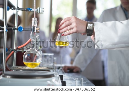 Laboratory equipment for distillation.Separating the component substances from liquid mixture.Pharmaceutical researcher holding Erlenmeyer flask demonstrating process in apparatus