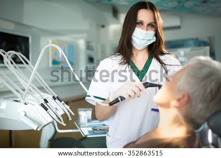 Professional woman dentist doctor working.Senior woman at dental clinic.Old lady woman at dentist taking care of teeth.Dental care for elder people.Dentist holding dental device for  fixing teeth.