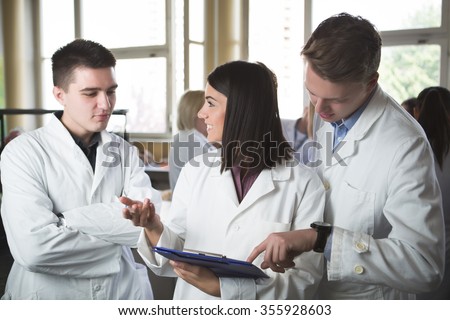 Scientific researcher holding a folder of chemical experiment research. University coworkers,Pharmacy,Medicine.Working in teams for a better result.Science project team work.