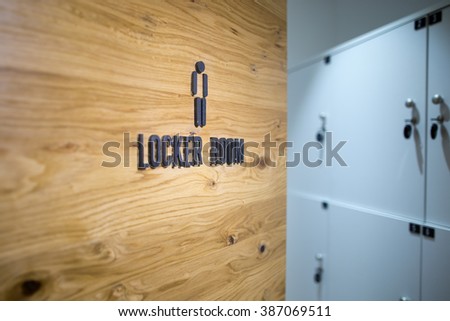 Entrance door to a men locker room in the gym.Spa,swimming pool,gym locker room door with caption sign and little grey lockers in the background.Sportsmen locker room.Sport changing room