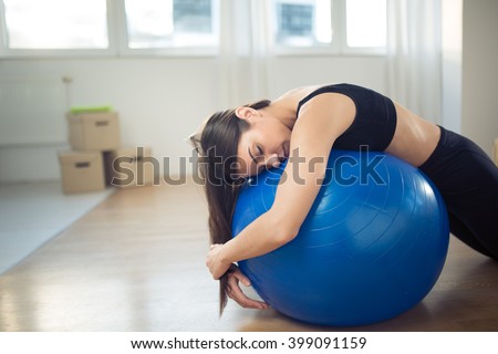 Disappointed fitness woman sitting on fitness pilates ball in room after work.Trying to work out exercise yoga and pilates.Discouraged,fitness disappointment with the progress.Tired lazy woman