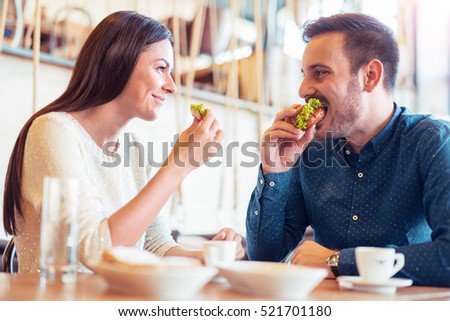 Happy loving couple enjoying breakfast in cafe. Love, food and  lifestyle concept.
