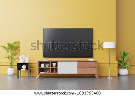 TV on cabinet  in modern living room with lamp,table,flower and plant on yellow wall background,3d rendering
