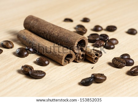 Cinnamon sticks and coffee seeds close up on wooden table