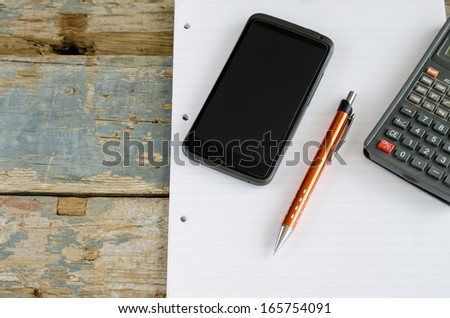 calculator, blank paper, pen and mobile, cell phone on wooden table, business concept