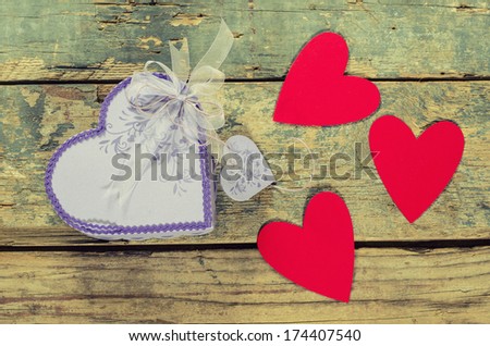 Heart shaped Valentines Day present gift box with small hearts around it on old wood.
