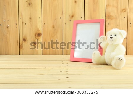 bear and blank pink frame on wood wall