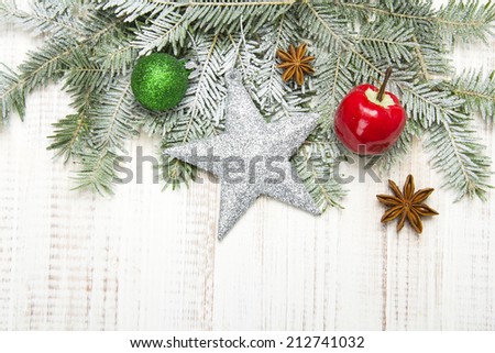 Christmas decoration with fir twigs, baubles, silver star and artificial snow with a blank space