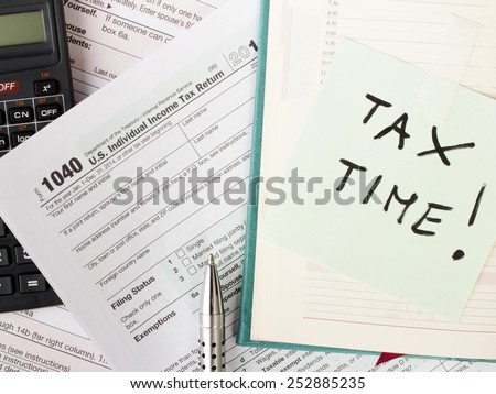 Close up U.S. Individual tax form 1040 with calculator and pen.
