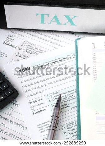 Close up U.S. Individual tax form 1040 with calculator and pen.