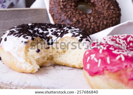 bitten donuts with icing on a white napkin
