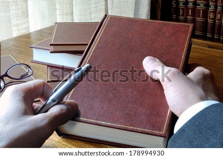 man who will take notes from a book, with window and library background