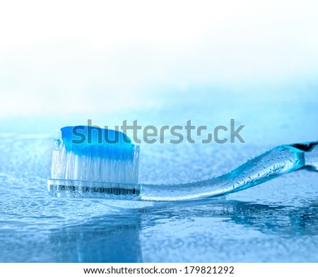 toothbrush with paste on glass with water splashes, backlight