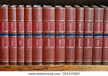 row of books with brown cover on a shelf with titles in Spanish