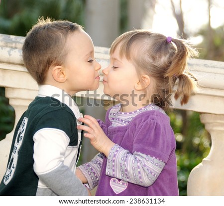 shy girl and boy kissing tenderly in the park