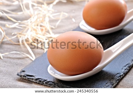 eggs in ceramic spoon on slate base on a table