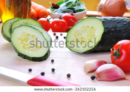 cucumber sliced on a cutting board with vegetables background