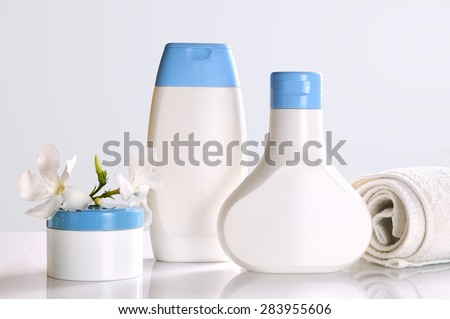 body care and beauty products in white and blue containers on a white table glass in a bathroom front view. Isolated.