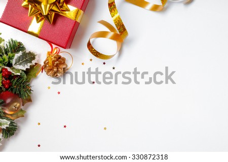 Christmas decoration isolated white on the left. Red and gift box and golden ribbon with floral ornament. Top view. Horizontal and diagonal composition.