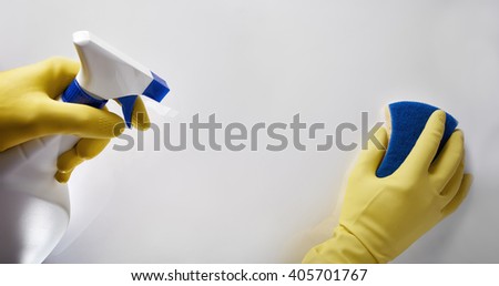 Hands of cleaning staff with sprayer and scourer working on white table. Top view. Horizontal composition.