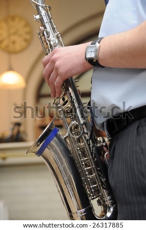 Man playing sax or brass horn (musical instrument). Hands close up