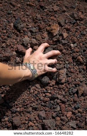 woman hand pick up volcanic stones