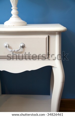 white bedside table and lamp with blue lampshade