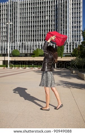 brunette woman with red suitcase walking in Madrid city Spain