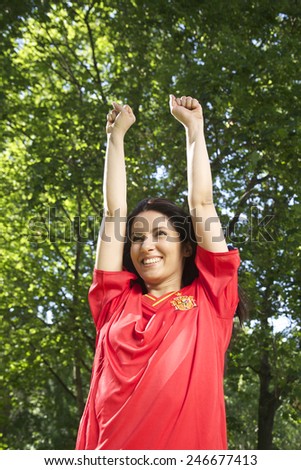 woman with spanish football team shirt cheering happy