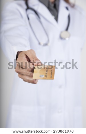 woman doctor with white gown and stethoscope offering made-up fiction credit card with chip in her hand