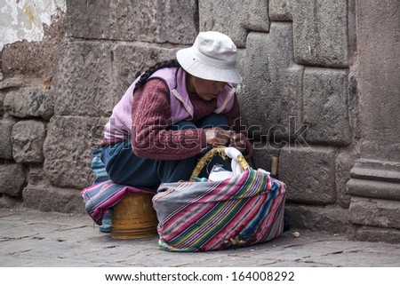 CUZCO, PERU - MARCH 8: A Peruvian woman peels potatoes on a street corner on March 8, 2013 in Cuzco, Peru.
