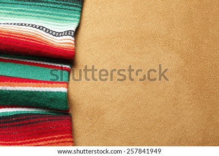 Colorful Mexican blanket on a brown suede surface