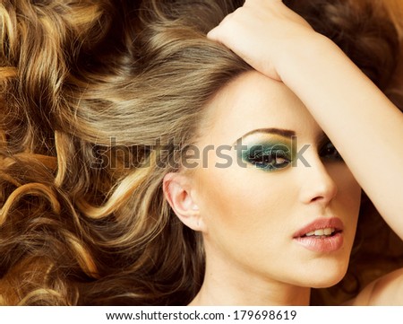 Conceptual photo of attractive young woman posing with amazing makeup and hairstyle.