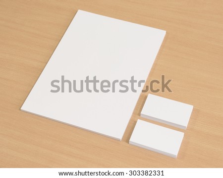 Blank business cards with a pile of papers. Mockup on wooden office table.
