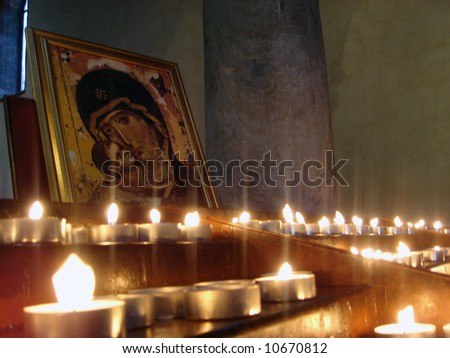 Painting of Mary and Baby Jesus, lit with candles.