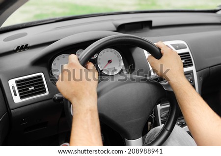 Man driving his car. Hands holding the wheel.