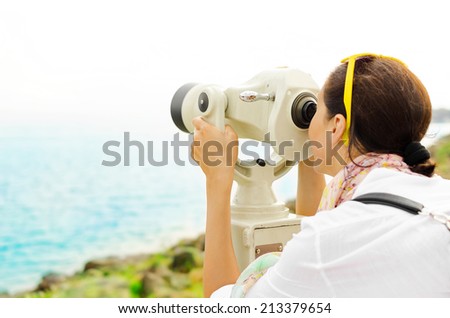 Woman looking through binoculars or telescope