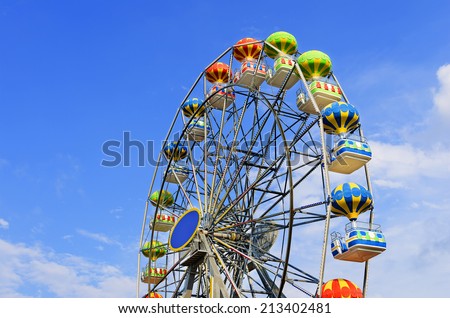 Ferris wheel on the background of blue sky with cloud