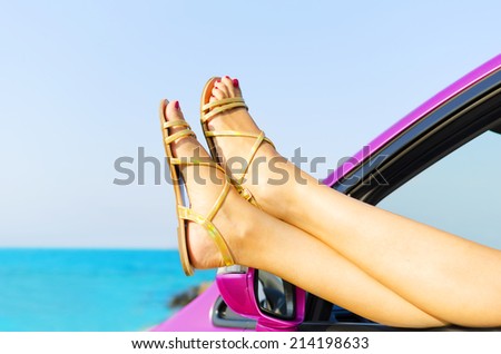 Travel vacation freedom beach concept. Female legs out of car window.