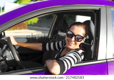 Woman drives a car and smiling