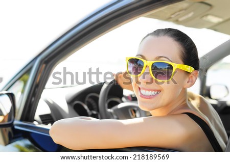 Woman drives a car on the road and smiling