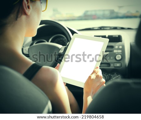 Woman in the car with tablet pc. Vintage photo.