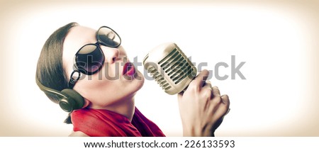 Singer with old microphone in black glasses